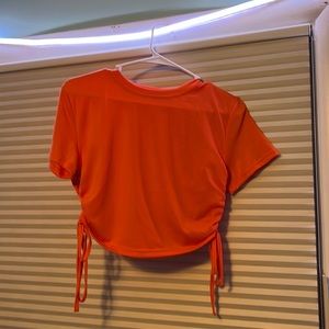 orange cropped baby tee with scrunch details on sides and ties.